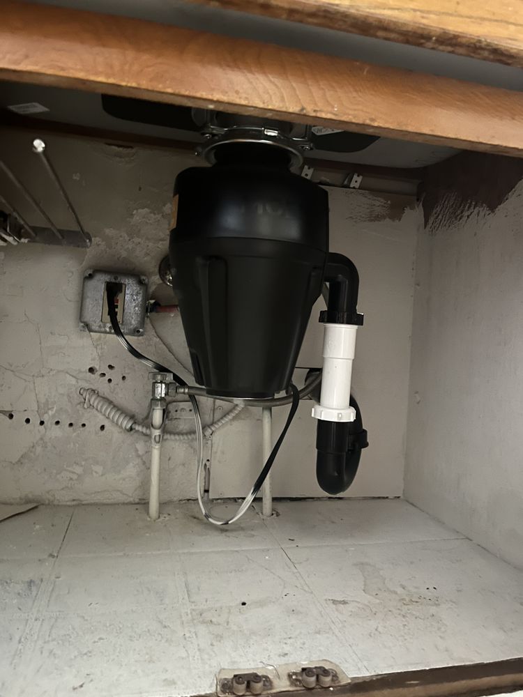 New disposal unit installed in compact under-sink cabinet