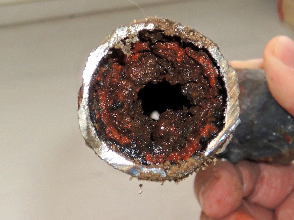 Heavy corrosion and rust inside old drain pipe — typical problem we fix